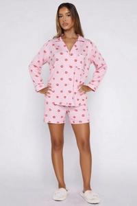 Close-up of pink long-sleeved pajamas with red lip prints and button-down collar