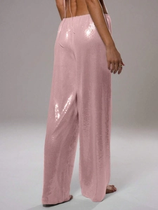 Détail du pantalon large à paillettes roses avec tissu fluide et reflets brillants