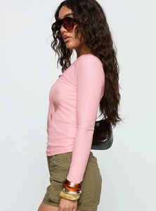 Dettaglio del top rosa a maniche lunghe slim fit con stampa floreale e profilo laterale