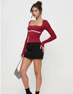 Detail of burgundy long sleeve top with square neck and white lace stitching accents