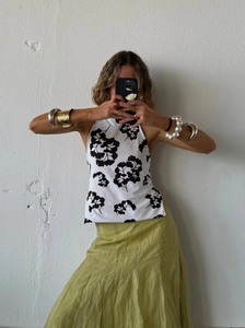 Detail view of white halter top with black ginkgo leaf print and asymmetrical hemline