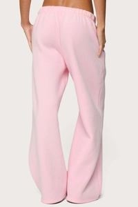 Detail view of baby pink women's joggers with elastic waist and soft fleece texture