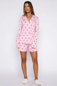 Close-up detail of soft pink pajama set featuring red lip prints and fine button stitching