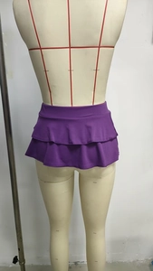 Dettaglio della minigonna a pieghe viola scuro con design dell'orlo a doppio balzo
