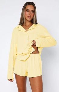 Detailed shot of yellow long-sleeved shirt and matching shorts loungewear set on a model