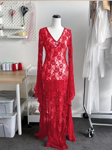 Detail of red floral lace dress featuring deep V-neckline and metal hardware accent