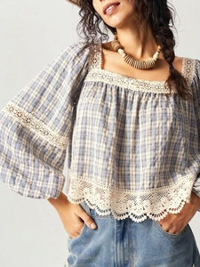Detailed shot of blue plaid shirt with intricate white crochet lace and puff sleeves