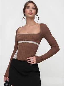 Close-up detail of dark brown cable knit top with white lace square neckline