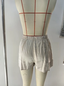 Détail du short en satin champagne avec bordure en dentelle florale et taille élastique