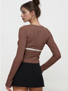 Detail view of cable-knit long sleeve shirt with white lace patchwork on the back