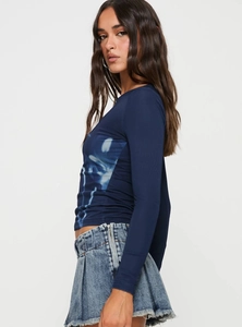 Dettaglio della stampa floreale blu e della trama del tessuto aderente sul crop top a maniche