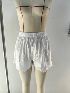 Vue détaillée du short en satin blanc avec bordure en dentelle florale et taille élastique