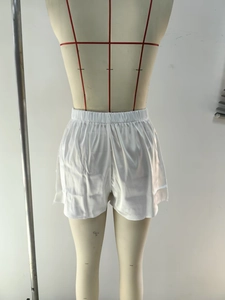 Gros plan détaillé du short en satin blanc avec dentelle et taille élastique froncée