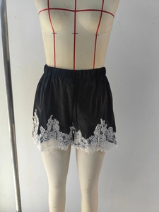 Détail du short en satin avec bordure en dentelle blanche et taille élastique sur mannequin