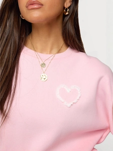 Pink crewneck hoodie with white lace heart pattern and elegant gold necklace detail