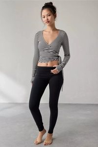 Detail of wrap-style long sleeve top with black and white stripes and side tie design