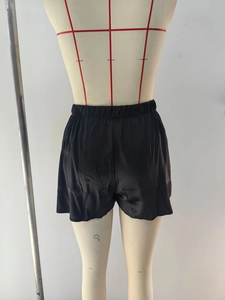 Gros plan d'un short en satin noir montrant la taille élastique et la texture lisse