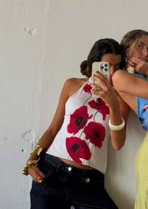 Detailed view of elegant white halter neck top featuring artistic red poppy flower prints