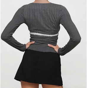 Detail of grey ribbed long sleeve top with elegant white lace stitching on the back