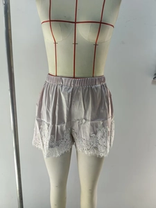 Détail du short en satin lavande avec bordure en dentelle blanche et taille élastique