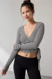 Detail of black and white striped crop top with V-neck and thumbhole sleeves
