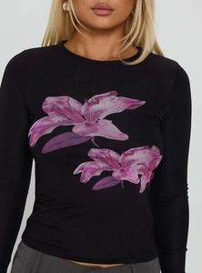 Dettaglio della maglia nera slim-fit a maniche lunghe con stampe vintage di fiori viola