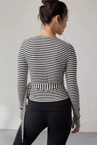 Close-up back view of a striped wrap top showing the waist tie and slim fit design