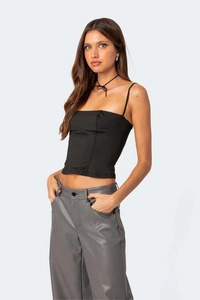 Detail eines schmal geschnittenen schwarzen Korsett-Tops mit dünnen Trägern und Choker