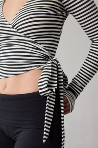 Detail of long sleeve wrap top featuring classic black and white stripes and waist tie