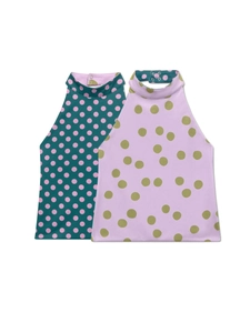 Detail view of two baby halter vests with pink polka dots and snap buttons on the back