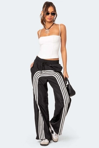 Detail von weißem Crop-Camisole kombiniert mit gestreifter Hose und schwarzer Handtasche
