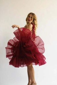 Details von dunkelrotem Stufenkleid mit voluminösen Tülllagen und Schulterbändern