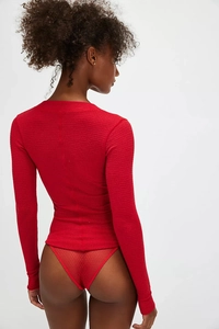 Detail of red waffle knit long sleeve top showing slim fit cut and textured fabric