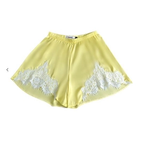 Vue détaillée du short en soie jaune pâle avec dentelle blanche délicate et taille élastique