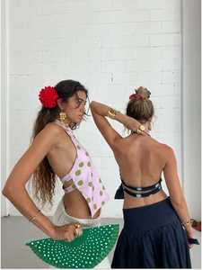 Detail of polka dot halter tops with elegant open back and golden jewelry accessories