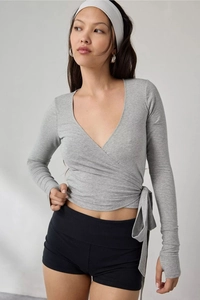 Detail of grey wrap-style V-neck long sleeve top with waist ties and thumbhole cuffs