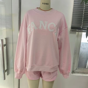 Detalle de la sudadera rosa de manga larga con bordado de letras FANCY en blanco