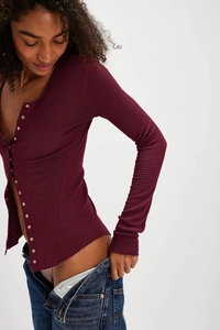 Detail showing the burgundy waffle knit texture and golden buttons on the slim cardigan