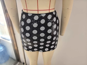 Detail of black mini skirt with shiny silver sequins and large polka dot pattern