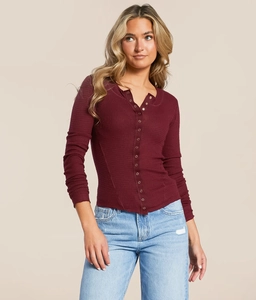 Detailed texture of burgundy waffle knit Henley top with buttons and slim fit sleeves