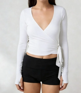 Detail of white wrap top with V-neck, side bow-tie, and ribbed fabric texture