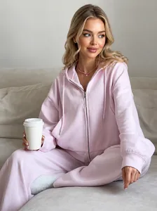 Detail of pink cotton tracksuit with drawstring hoodie and jogger pants in a cozy setting