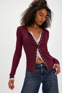 Close-up of waffle knit texture and delicate lace trim on dark purple cardigan sleeves