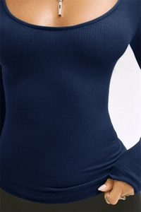 Detailed view of the dark blue ribbed knit fabric and slim fit U-neckline design