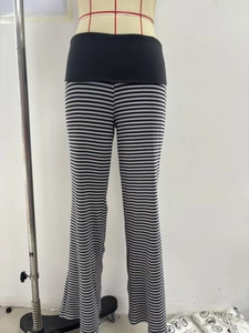 Macro detail of high-waist band on black and gray striped flared trousers with stitching