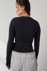 Detail of slim fit black long sleeve top featuring adjustable back tie-up waist design