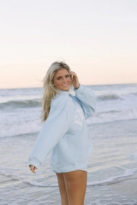 Primer plano de conjunto de sudadera de algodón azul claro con letras en la playa