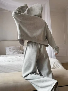 Relaxed fit grey hooded cotton tracksuit set featuring wide-leg pants in a bedroom setting
