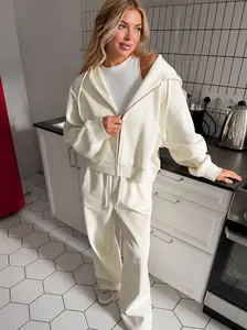 Detail of cream white fleece hoodie and matching wide-leg trousers in a home setting