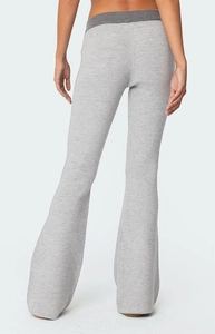 Détail de pantalon évasé gris montrant la texture en maille côtelée et la taille contrastée